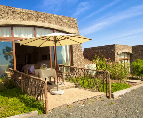 Bedroom and dining table on veranda at Gondar Hills Resort