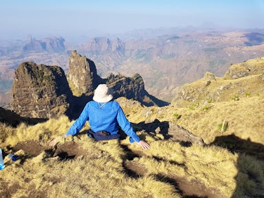 Man sitting on ledge looking at landscape in the Simien Mountains